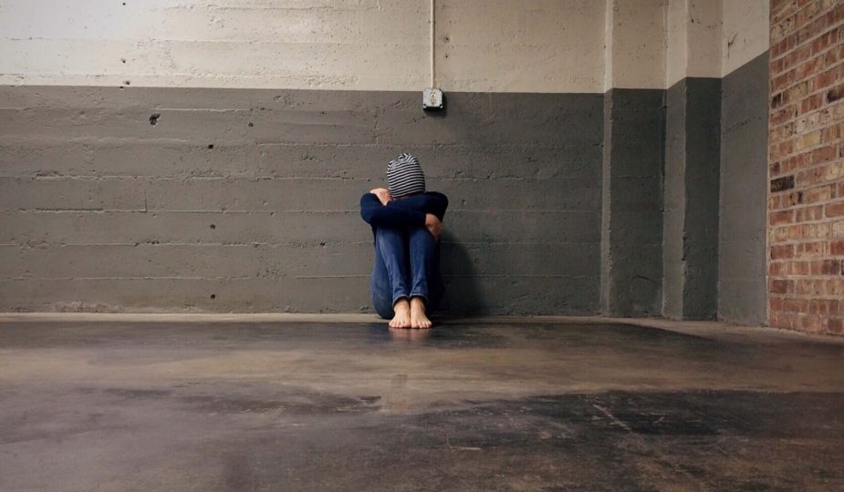 boy sitting alone in a hallway