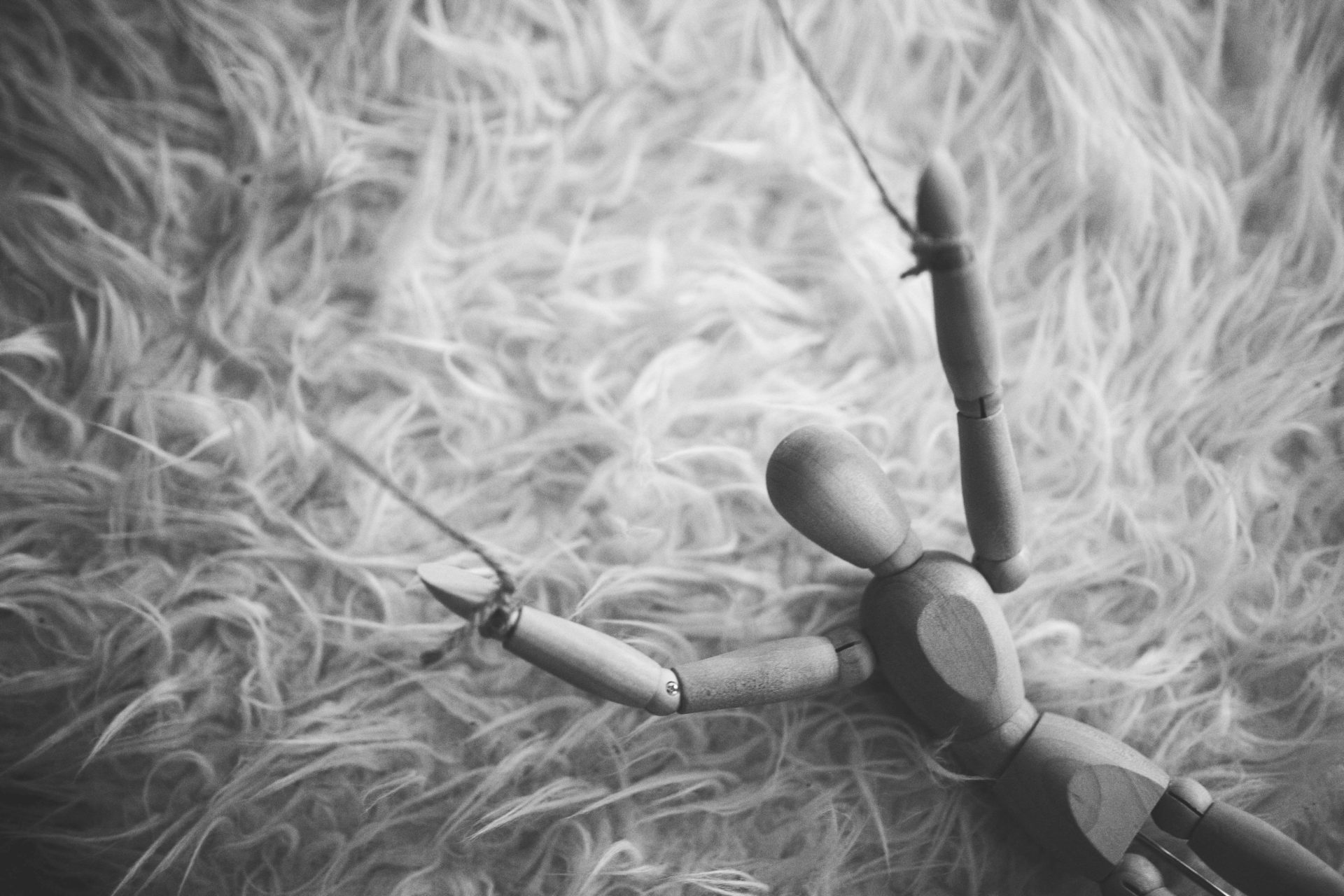 a wooden puppet doll with strings on its arms