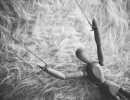 a wooden puppet doll with strings on its arms
