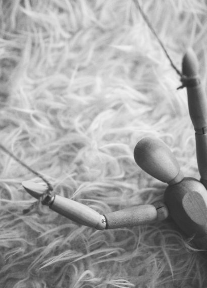 a wooden puppet doll with strings on its arms